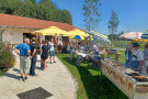 Sonnenschirme und Grill für Fische auf der Wiese vor dem Dorfgemeinschaftshaus