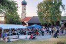 Ein Bild von Frauen mit Kindern vor einem kleinen Zelt. Bunte Lampions sorgen für feierliche Stimmung.