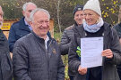 Ein Mann vom Amt übergibt der Vereinsvorsitzende die Förderurkunde.