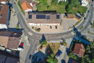 Blick von oben auf eine Straßenkurve mit Haus.