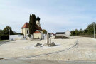Der neue Kirchenvorplatz mit der Statue des Heiligen Leonhards. Im Hintergrund die Kirche.