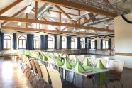 Ein schöner heller Saal, in der Mitte eine gedeckte Tafel.
