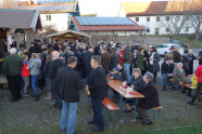 Menschen stehen zusammen oder sitzen auf Bierbänken 