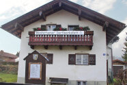 Ein Haus mit einem Banner auf dem Dorfwerkstatt steht.