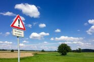 Verkehrsschild mit Hinweis auf Straßenschäden
