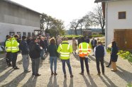 Gruppe von Personen steht in einem Kreis versammelt in einem Hof