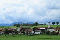 Malerisches Dorf mit Kirche und Bergpanorama