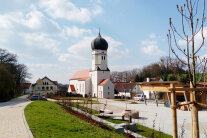 Kirche mit neuem Dorfplatz und Maibaum.