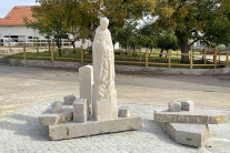 Der Brunnen mit der Statue des Heiligen Leonhards auf dem Kirchenvorplatz